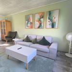 Wohnzimmer mit Sofa, Couchtisch und Wandbildern.