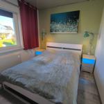 Schlafzimmer mit Bett, Nachttischen und Fensterblick auf Garten