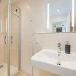Bad mit Dusche und Waschbecken mit Spiegel