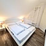 Schlafzimmer mit Doppelbett, Nachttischen und Kleiderschrank.