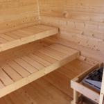 Sauna mit Holzbanken und Heizsteinbehälter