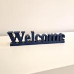 Ein dunkelblaues Welcome-Schild steht auf einer weißen Oberfläche.