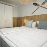Schlafzimmer mit Bett, Kleiderschrank und Wanddekoration