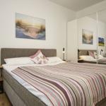 Schlafzimmer mit Bett, Nachttisch und Wandbildern