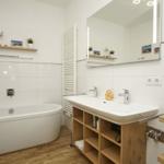 Badezimmer mit Badewanne, Waschbecken und Spiegel