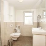 Badezimmer mit Dusche, Toilette und Waschbecken.