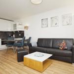 Wohnküche mit Sofa, Esstisch und moderner Einrichtung.