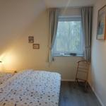 Schlafzimmer mit Doppelbett, Fenster und Kleiderständer