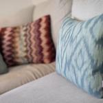 Ein Sofa mit mehreren Kissen in verschiedenen Mustern und Farben.
