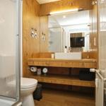 Badezimmer mit Holzwand, Waschtisch und Dusche