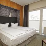 Schlafzimmer mit Doppelbett, Holzmöbel und Fenster mit Blick.