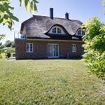 Haus mit Strohdach, Backsteinfassade und Garten