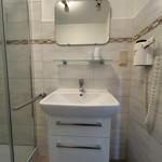 Badezimmer mit Dusche, Waschbecken und Spiegel