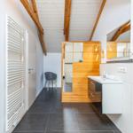 Badezimmer mit Holzumrandung, Waschbecken und Heizkörper an der Wand.