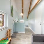 Flur mit Fenster, Sofa und Kinderzimmermöbel. Holzbalken an der Decke.