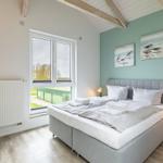 Schlafzimmer mit Doppelbett, Fenster und Wandbildern