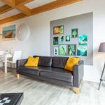 Ein Wohnzimmer mit Sofa, Tisch, Wanddekoration und Holzdecke.