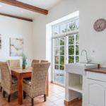 Dining room with table, chairs, and kitchen area with sink