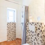 Bathroom with shower, mosaic wall, and window