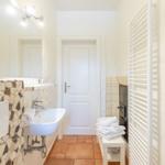 Bathroom with sink, mirror, towel rack, and heater.