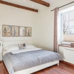 Bedroom with bed, dresser, and window. Wall art shows landmarks.