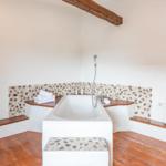 Bathroom with bathtub, mosaic tiles, and wooden floor