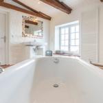 Bath with bathtub, mirror, and window