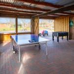 Hallenbereich mit Tischtennis- und Fußballtisch, Holzwände und Fenster zur Außenseite.