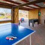 Spielzimmer mit Tischtennis- und Fussballtisch, Holzwand und Terrasse mit Blick auf Garten.