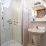 Bathroom with shower, sink, and mirror on the wall.