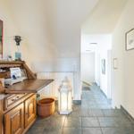 Hausflur mit Holzschrank, Wandbild und beleuchteter Laterne.