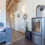 Wohnzimmer mit Sofa, Kaminofen und Holzboden