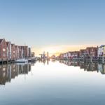 Harbor canal with boats and reflections at sunset