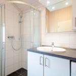 Badezimmer mit Dusche, Waschbecken und Spiegel