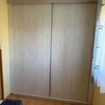 Schlafzimmer mit Schiebetürenschrank und Holzboden