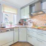 Kitchen with worktop, sink, range hood, and built-in oven.