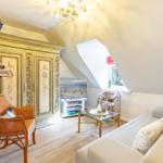 Living room with sofa, TV, and decorative cabinet under sloped ceiling