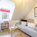 A living room with sofa, glass table, and window with red roller blind.