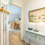 Entrance area with console table, painting, and view into dining room.