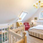 Bedroom with skylight, bed, armchair, and chandelier. Play area in foreground.