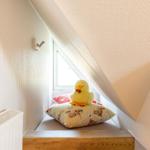 Attic corner with window, cushions, and plush duck.
