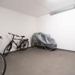 Tiefgarage mit drei Fahrrädern, eines davon zugedeckt.
