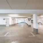 Untergeschoss-Parkhaus mit markierten Stellplätzen und Türen zu Parkgaragen.