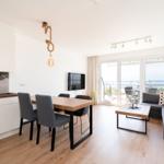 Wohnung mit Essbereich, Sofa und Blick auf die See
