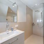Bathroom with shower, sink, and towel warmer for towels.