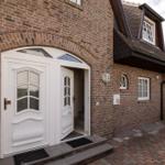 House with red brick, white entrance door, and dormer window.