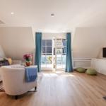 Living room with sofa, armchair, TV, and terrace door.