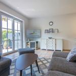 Wohnzimmer mit Sofa, Couchtisch und Blick auf den Garten.