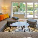 Wohnzimmer mit Sofa, Couchtisch und Blick auf den Garten.