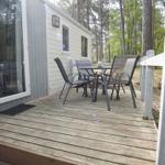 Terrasse mit Tisch und Stühlen vor einem Holzhaus im Wald